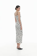 Montsand polka dot draped midi dress featuring a flowing silhouette and classic black and white polka dot pattern.