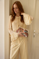 Brown clutch bag by Sarah's Bag with a detailed pomegranate and jungle design, featuring a stylish and elegant accessory.