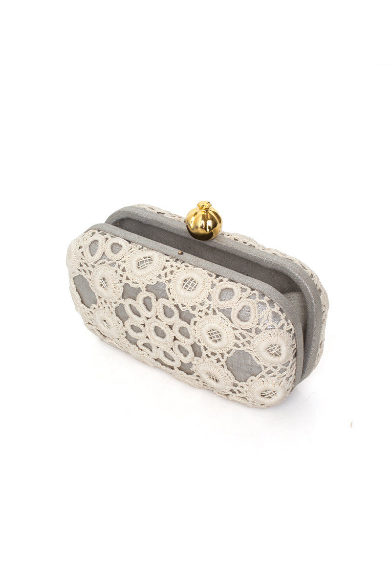 Silver clutch bag by Sarah's Bag featuring a pomegranate design and crochet detail on a sleek silver box clutch.