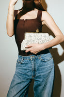 Silver clutch bag featuring a crocheted pomegranate design by Sarah's Bag, classic and stylish for elegant occasions.