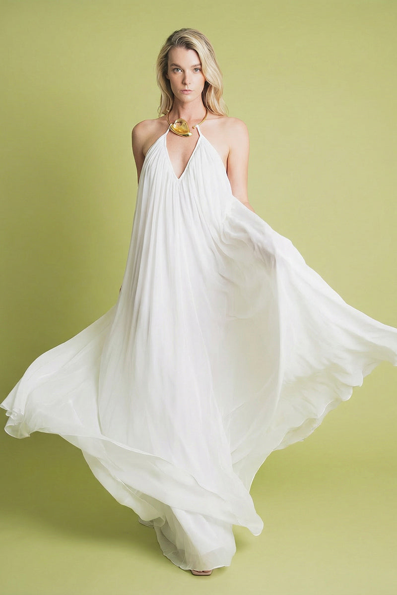 Ivory Portobello maxi dress by Laura Escobar displayed on a hanger, showcasing its flowing fabric and elegant design.