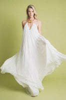 Elegant ivory maxi dress by Laura Escobar, featuring flowing fabric and a sophisticated design, perfect for formal occasions.