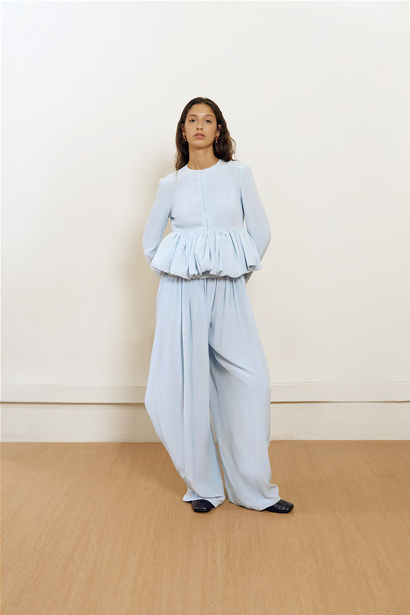 Back view of YASSMIN SALEH blue pouf jacket, stylish and cozy outerwear with a textured design and fitted silhouette.