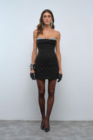 Nana Gotti Amal mini dress in vibrant fabric, featuring a fitted silhouette and stylish design, displayed on a hanger.