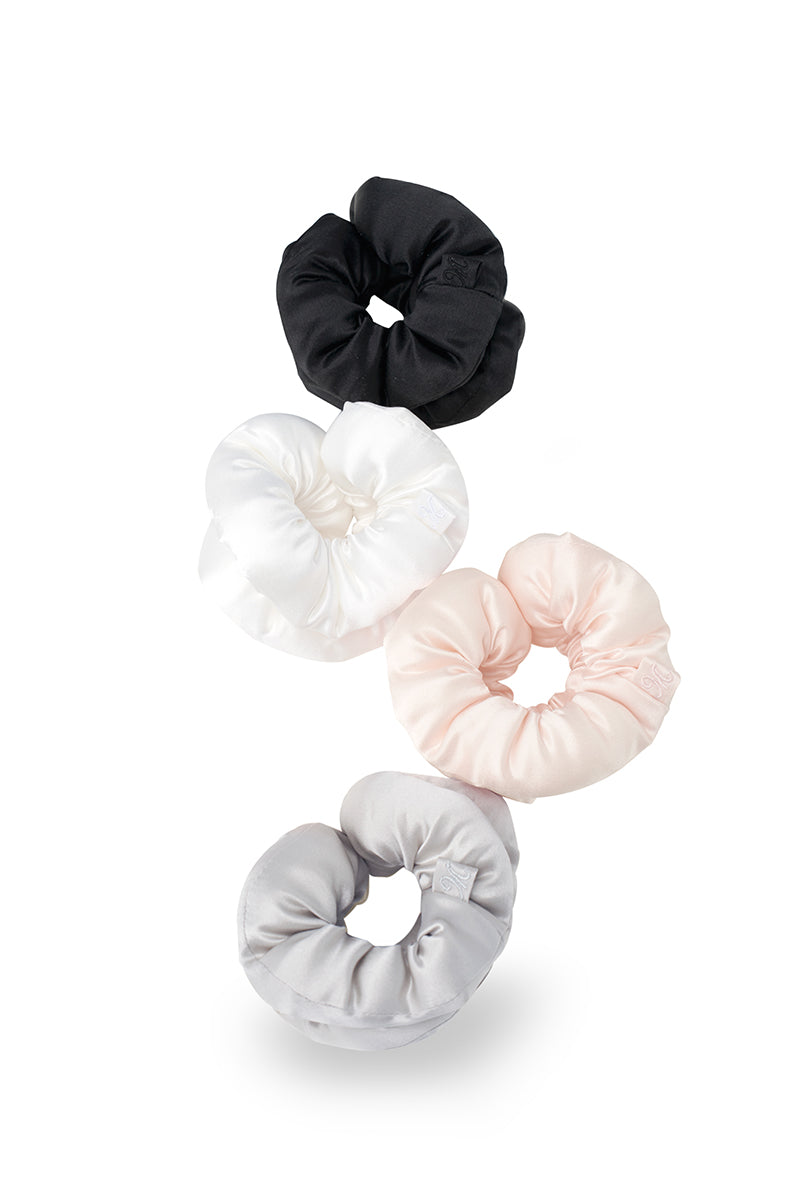 Set of puff hair scrunchies in gray, black, pink, and white made by MANITO, shown in a close-up image of the soft fabric accessories.