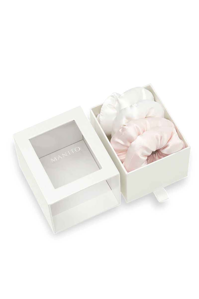 Pair of puff hair scrunchies in pink and white from MANITO, soft fabric hair accessories for styling or securing hair.