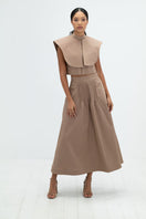 Camel midi skirt by ANA + MARIA featuring a high-waisted design and flowing fabric, shown on a neutral background.