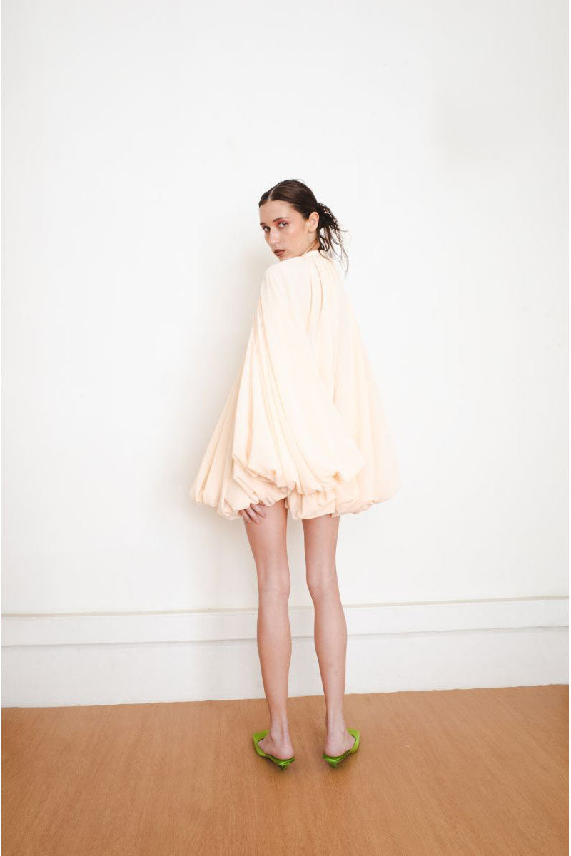 Back view of YASSMIN SALEH Quietude Ivory Mini Dress showcasing its elegant design and lightweight fabric.