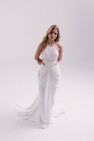 White VEYA gown by Francisco Arce, elegant and flowing dress with intricate detailing, perfect for formal occasions.