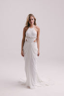White VEYA gown by Francisco Arce, elegant evening dress with flowing fabric and detailed design, suitable for formal occasions.