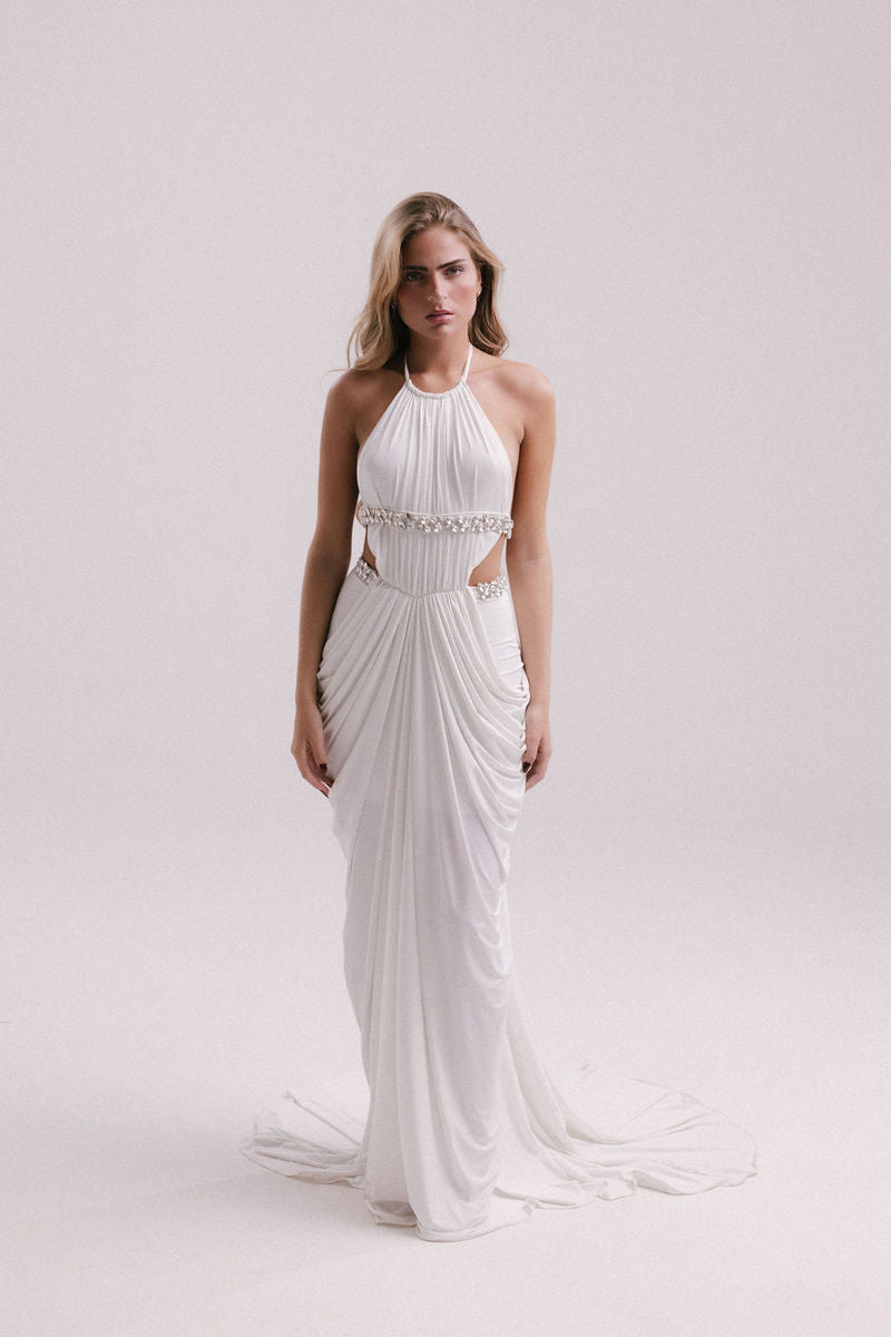 White VEYA gown by Francisco Arce, elegant evening dress with flowing fabric and detailed design, suitable for formal occasions.