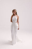 White VEYA gown by Francisco Arce, elegant floor-length dress with flowing fabric and sophisticated design.