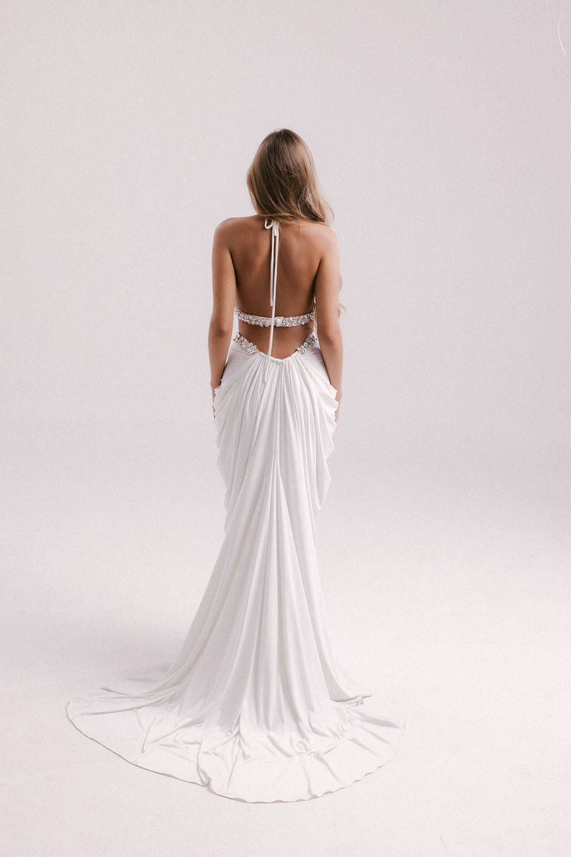 Elegant white gown by Francisco Arce, showcasing a flowing design with intricate details for formal occasions.
