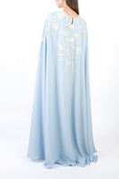 Light blue floral embellished maxi dress by SHATHA ESSA, shown from the back with intricate embroidery and flowing fabric.