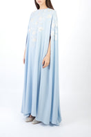 Light blue floral embellished maxi dress by Shatha Essa shown from the side view. Elegant, flowing fabric with detailed floral embroidery.