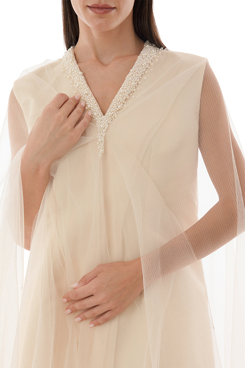 Close-up of Shatha Essa pearl-embellished drape detail cape gown, showcasing intricate pearl accents and elegant fabric draping.