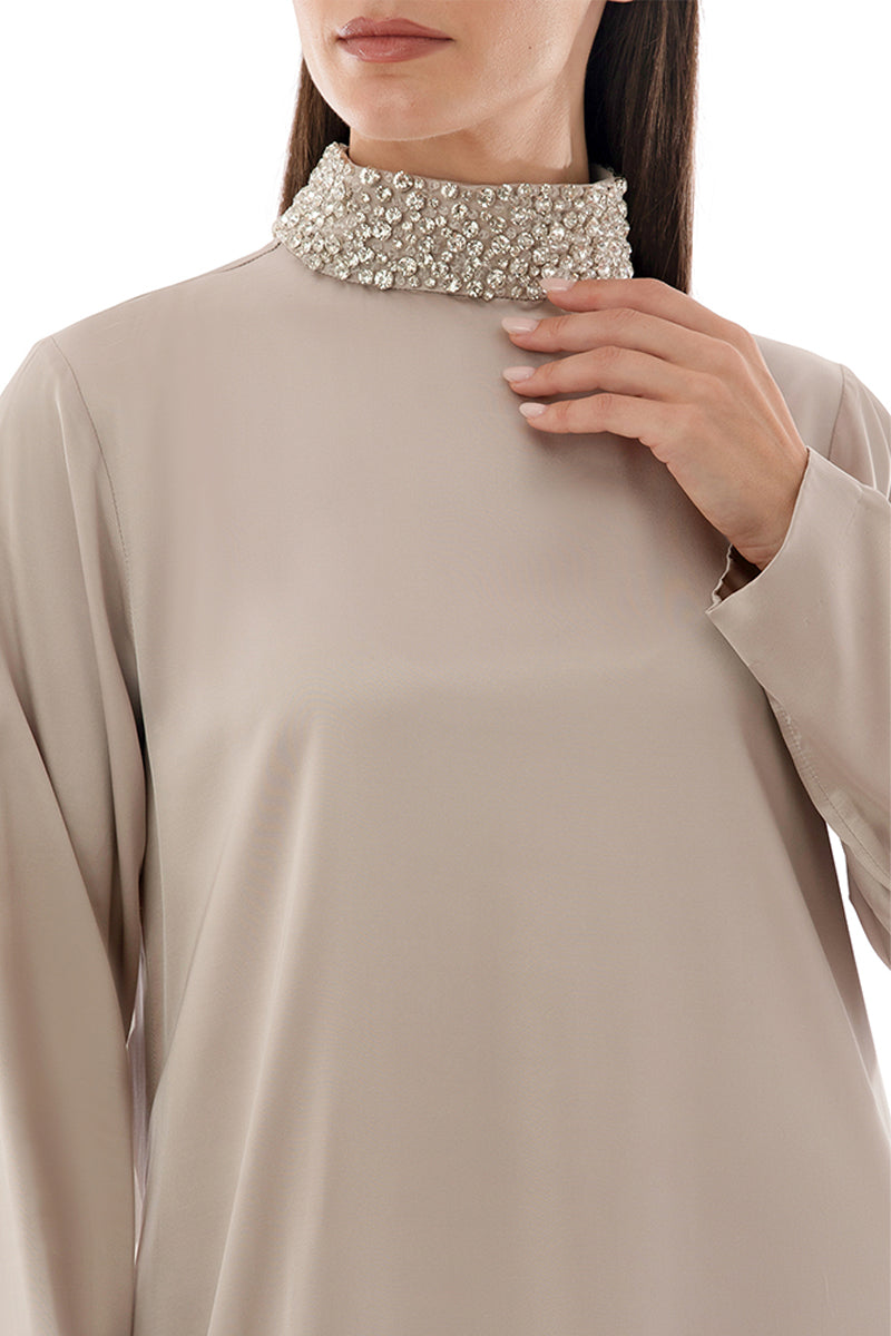 Close-up of a maxi dress by Shatha Essa featuring a crystal-embellished collar detail and elegant fabric.