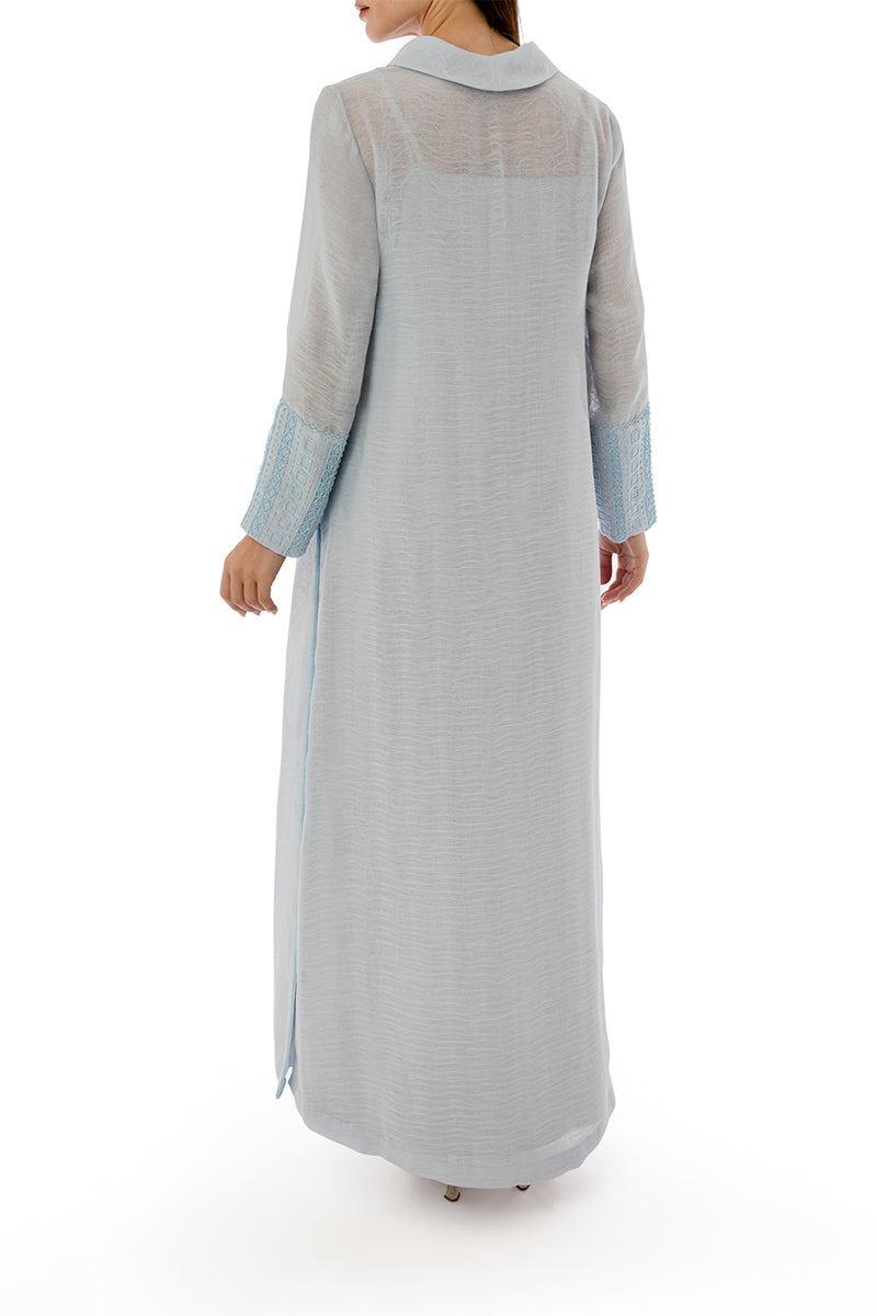 Back view of a SHATHA ESSA embroidered maxi dress with side slit detail and inner dress, showcasing elegant embroidery and flowing fabric.