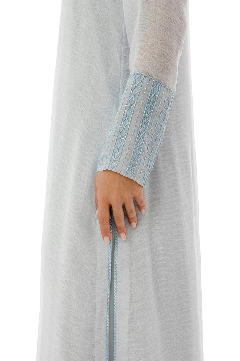 Close-up of a SHATHA ESSA embroidered maxi dress with side slit detail and inner dress, showcasing intricate embroidery and fabric texture.