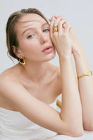 Gold RENASER earrings by Eugenia Ospina featuring sleek, modern design with smooth gold finish and elegant style.