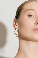 Silver RENASER earrings by Eugenia Ospina featuring intricate design with a polished finish and secure hooks.