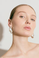 Silver RENASER earrings by Eugenia Ospina featuring intricate geometric designs and a polished finish.