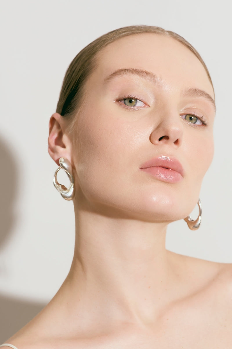 Silver RENASER earrings by Eugenia Ospina featuring intricate geometric designs and a polished finish.