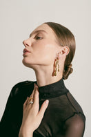 Gold earrings by Eugenia Ospina featuring a sleek, modern design with intricate details, perfect for stylish accessories.