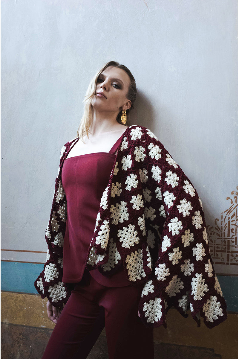 Jessica K burgundy and beige Rosa cardigan displayed on a hanger, featuring soft knit fabric and classic button details.