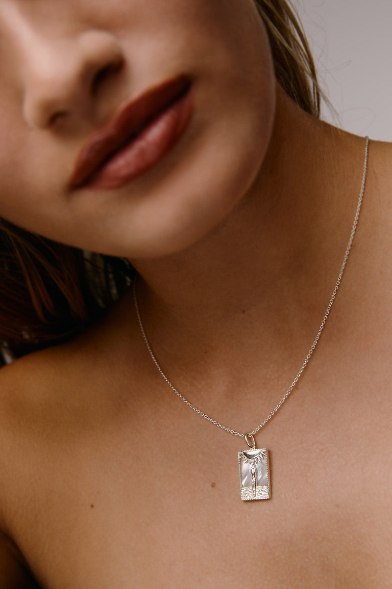 Sterling silver rectangle woman and sun necklace by Freya Rose, featuring a modern geometric design and sun motif.