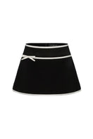 Black Victoria velvet mini skirt by Nana Jacqueline, shown on a model with a fitted waist and soft velvet texture.