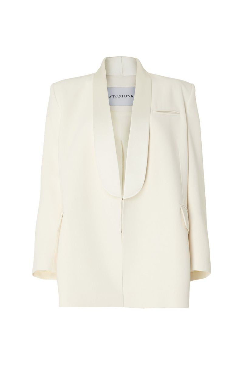 Studio NK ivory blazer from the ETHERAL collection displayed on a hanger, showcasing tailored fit and sleek design.