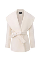 White Victoria Bow Coat by Nana Jacqueline displayed on a hanger, showcasing the elegant design and bow details of the stylish coat.