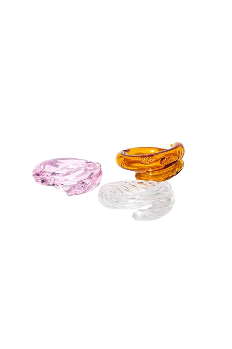 Set of pink, amber, and white Salvárea Remolino rings showcasing colorful, intertwined jewelry with intricate designs.