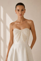 Nihan Peker vanilla ribbon gown with elegant flowing fabric and delicate ribbon details, perfect for formal occasions.