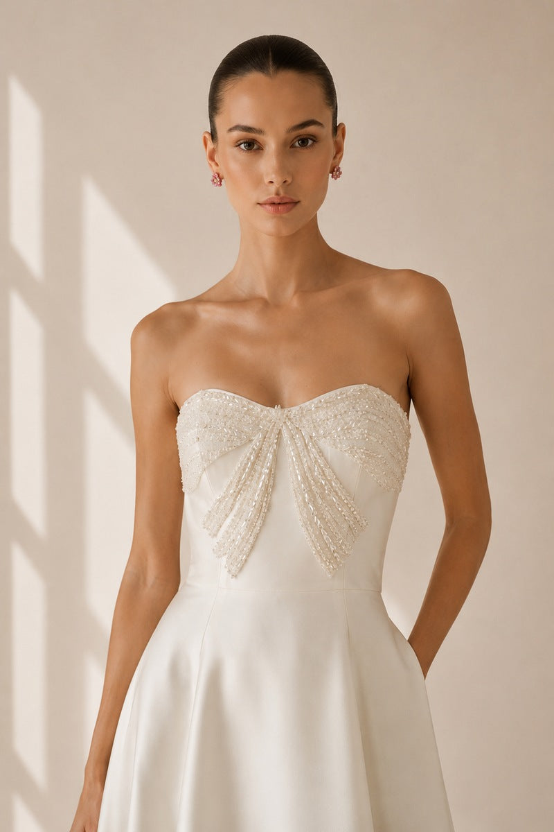 Nihan Peker vanilla ribbon gown with elegant flowing fabric and delicate ribbon details, perfect for formal occasions.