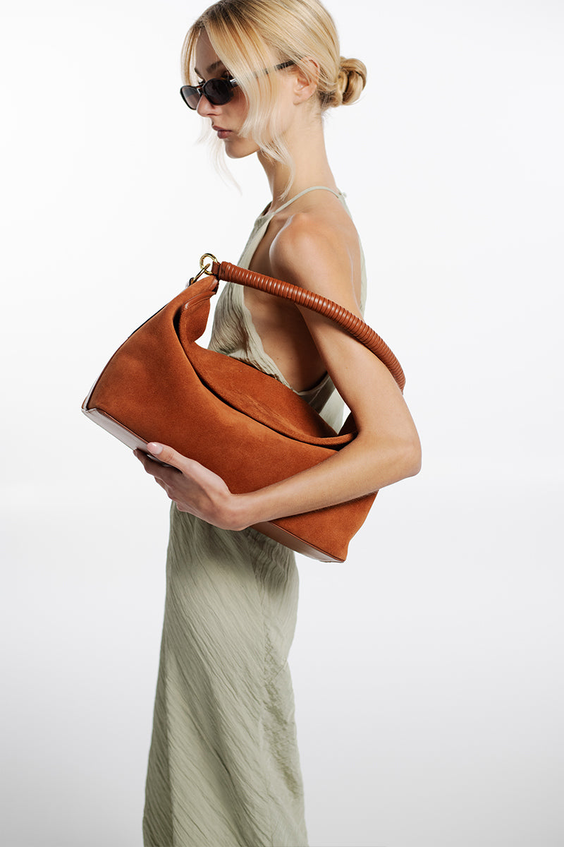 Tan suede Rivera handwoven top handle bag by Isidora Malva with elegant design and sturdy top handle.
