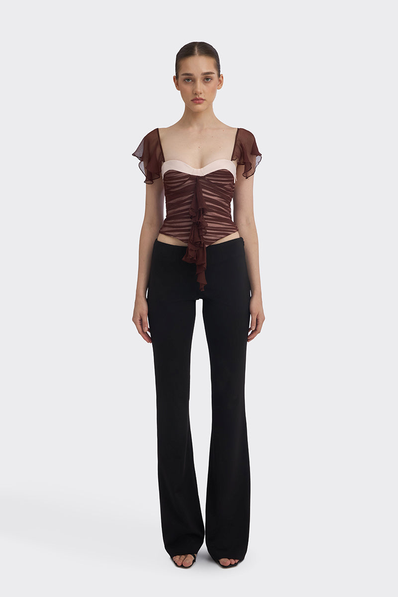 Brown ruched mini top by Stolen Stores, featuring gathered fabric and a fitted style, shown on a model.