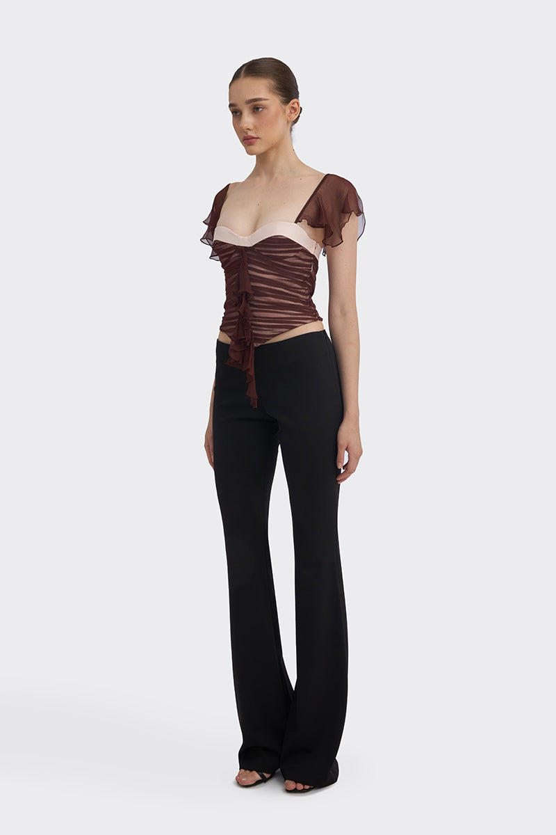 Brown ruched mini top by Stolen Stores, showing close-up of gathered fabric and stylish design on a fashion model.