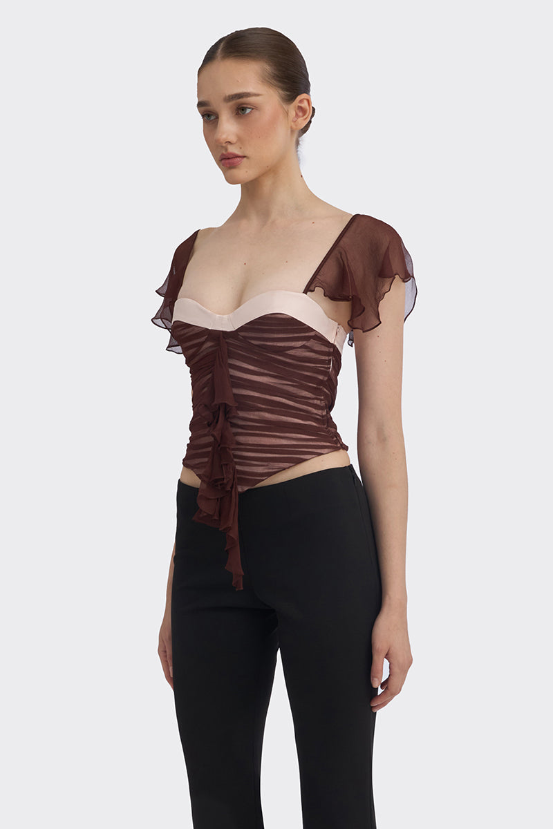 Brown ruched mini top by Stolen Stores, featuring gathered fabric and a fitted design, shown on a model.