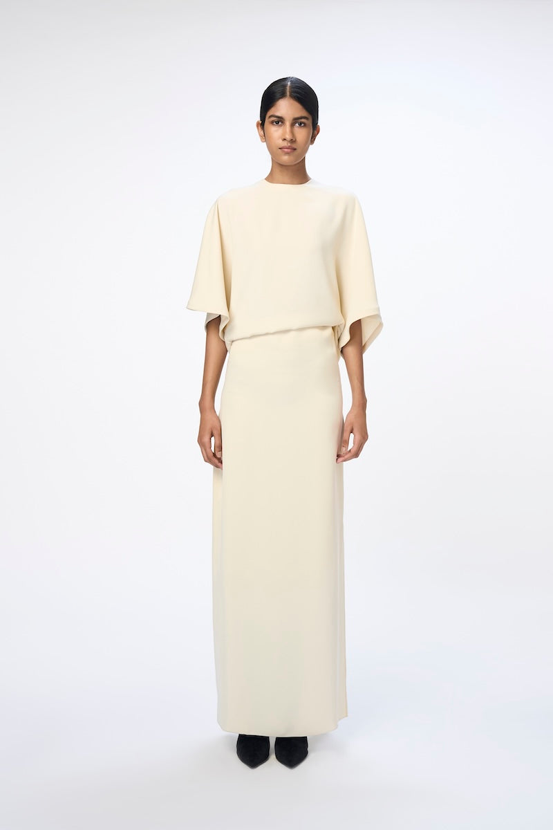 White URA RUNA maxi dress with a flowing silhouette, perfect for casual or elegant occasions.