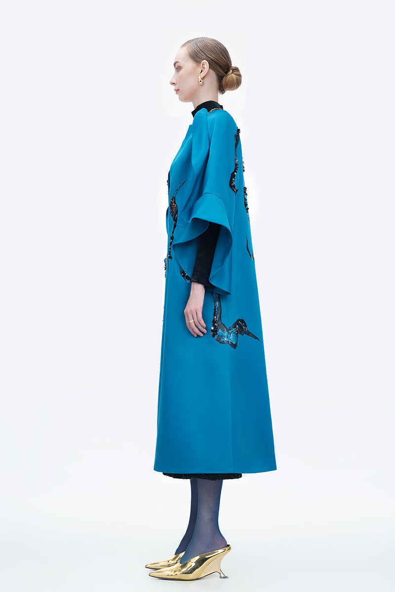 Blue Poppy of the Moon coat by Tiny Ink, stylish and cozy outerwear with floral design, displayed on a hanger.