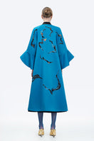 Blue Poppy of the Moon coat by Tiny Ink, stylish and cozy outerwear with floral design, shown on a model.
