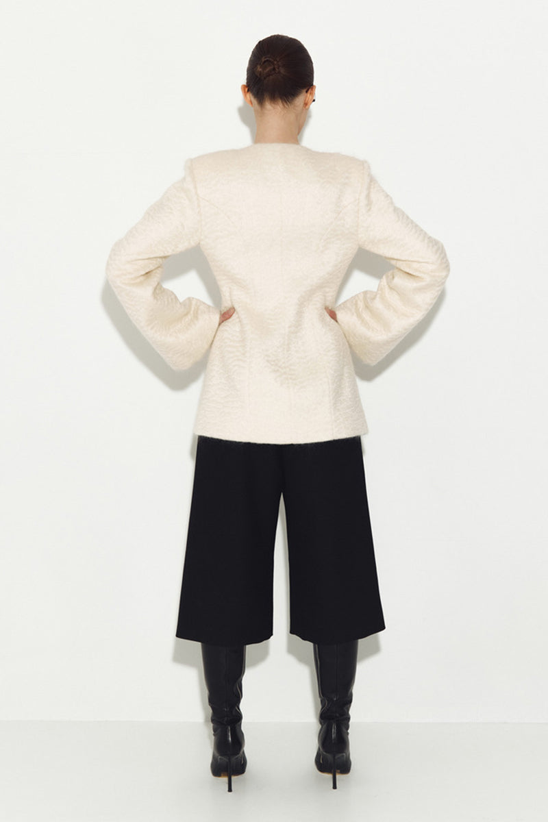 White Mohair jacket by Sayya, stylish and cozy outerwear with a soft, textured knit fabric, displayed on a hanger.