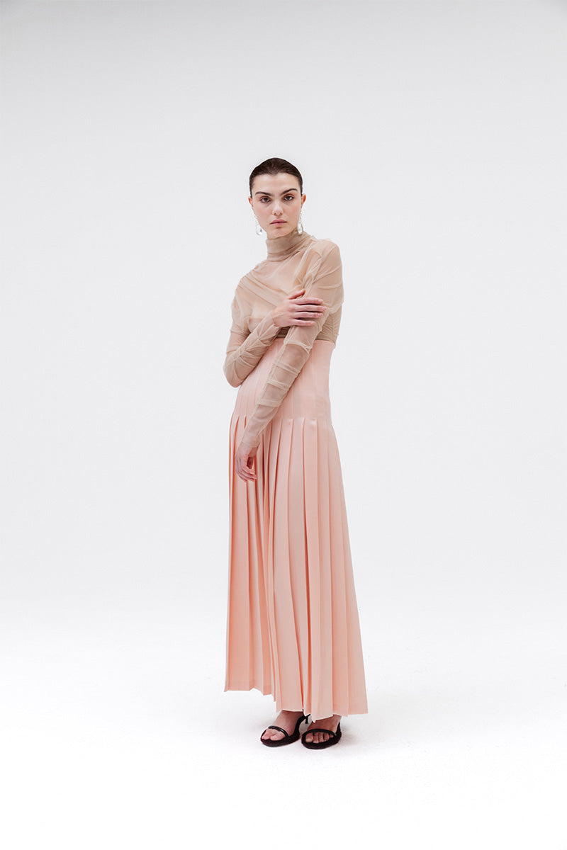 Peach-colored Studio NK sand blouse, a stylish women's top with a relaxed fit and soft fabric, displayed on a hanger.