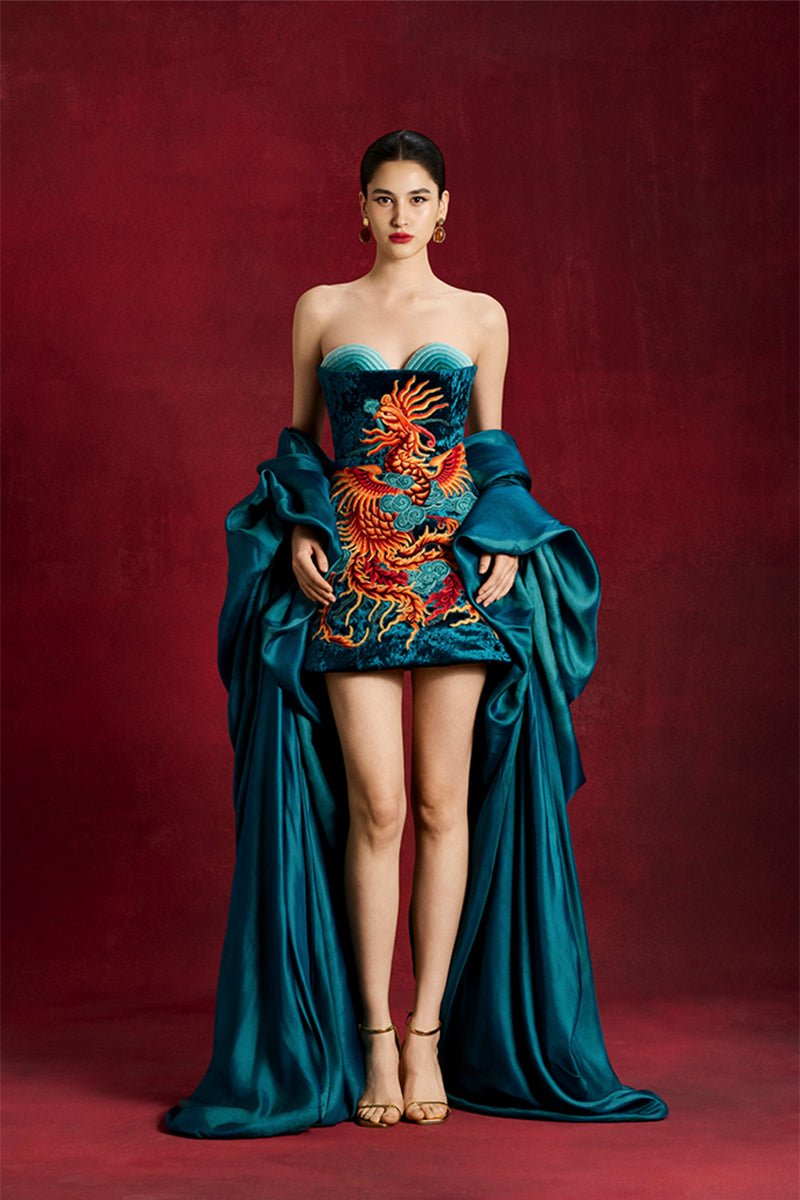 Le Thanh Hoa Azure Phoenix mini dress featuring vibrant blue fabric and intricate phoenix embroidery, stylish and elegant.