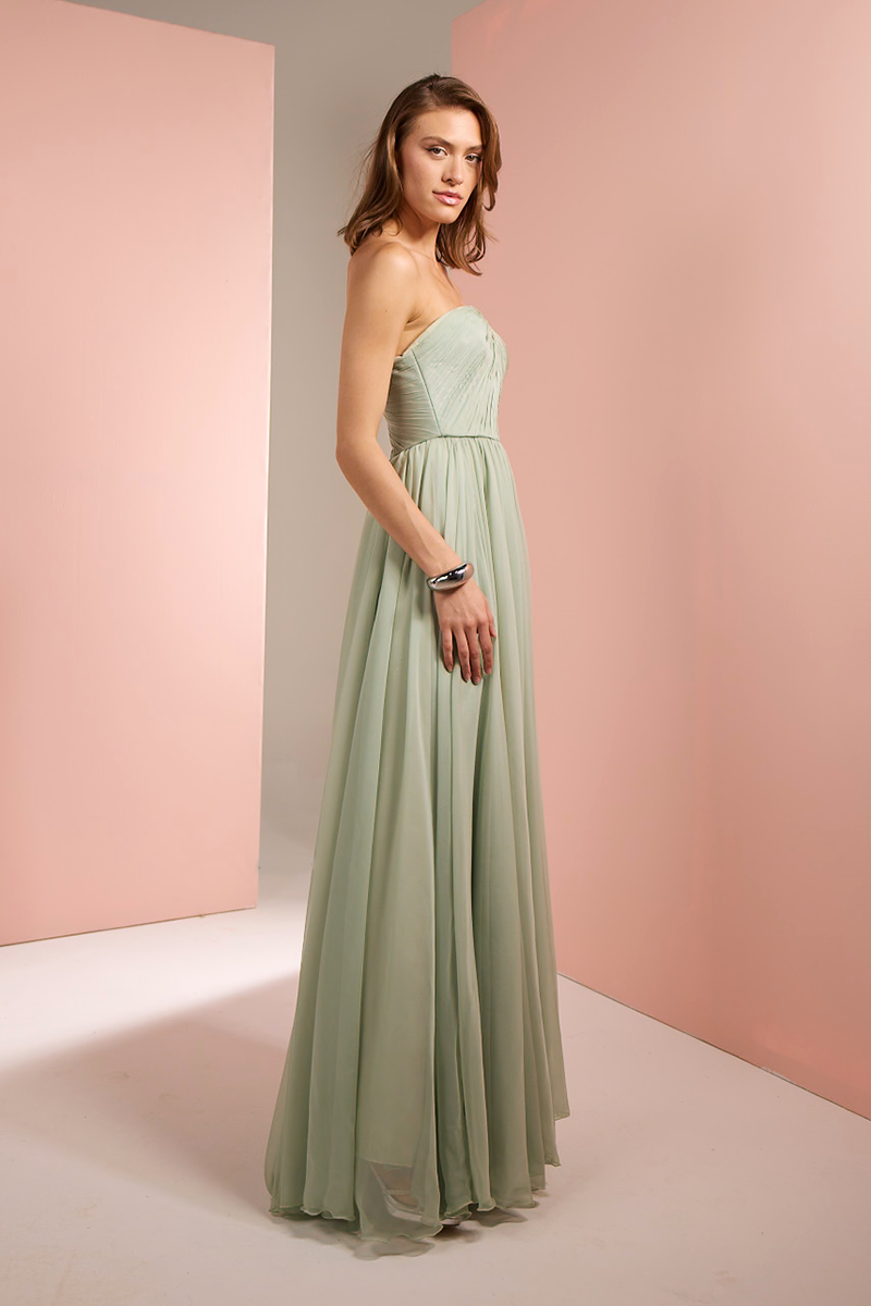 Light green strapless gown by Joanna Andraos, shown from side view with flowing fabric and elegant design.