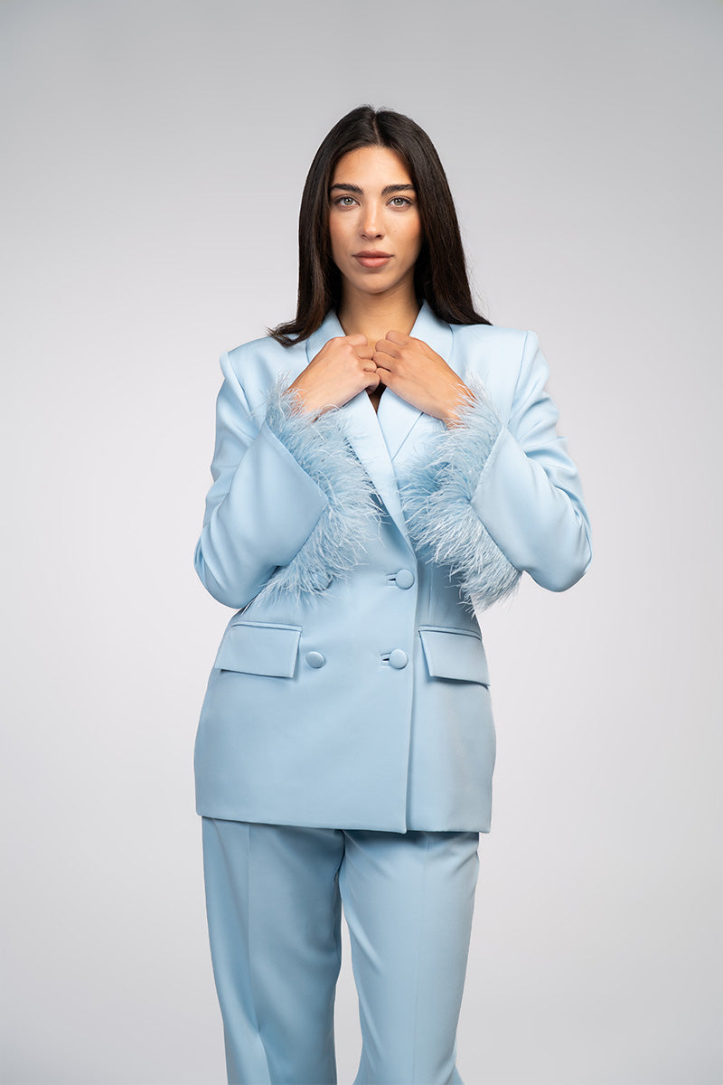 Baby blue hourglass suit set with feather details, designed by Joanna Andraos, featuring a stylish and elegant fashion look.