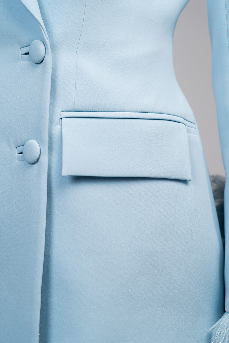 Baby blue hourglass suit set with feather details from Joanna Andraos, featuring a fitted design and elegant feather accents.