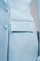 Baby blue hourglass suit with feather accents by Joanna Andraos, featuring a fitted silhouette and elegant feather details.
